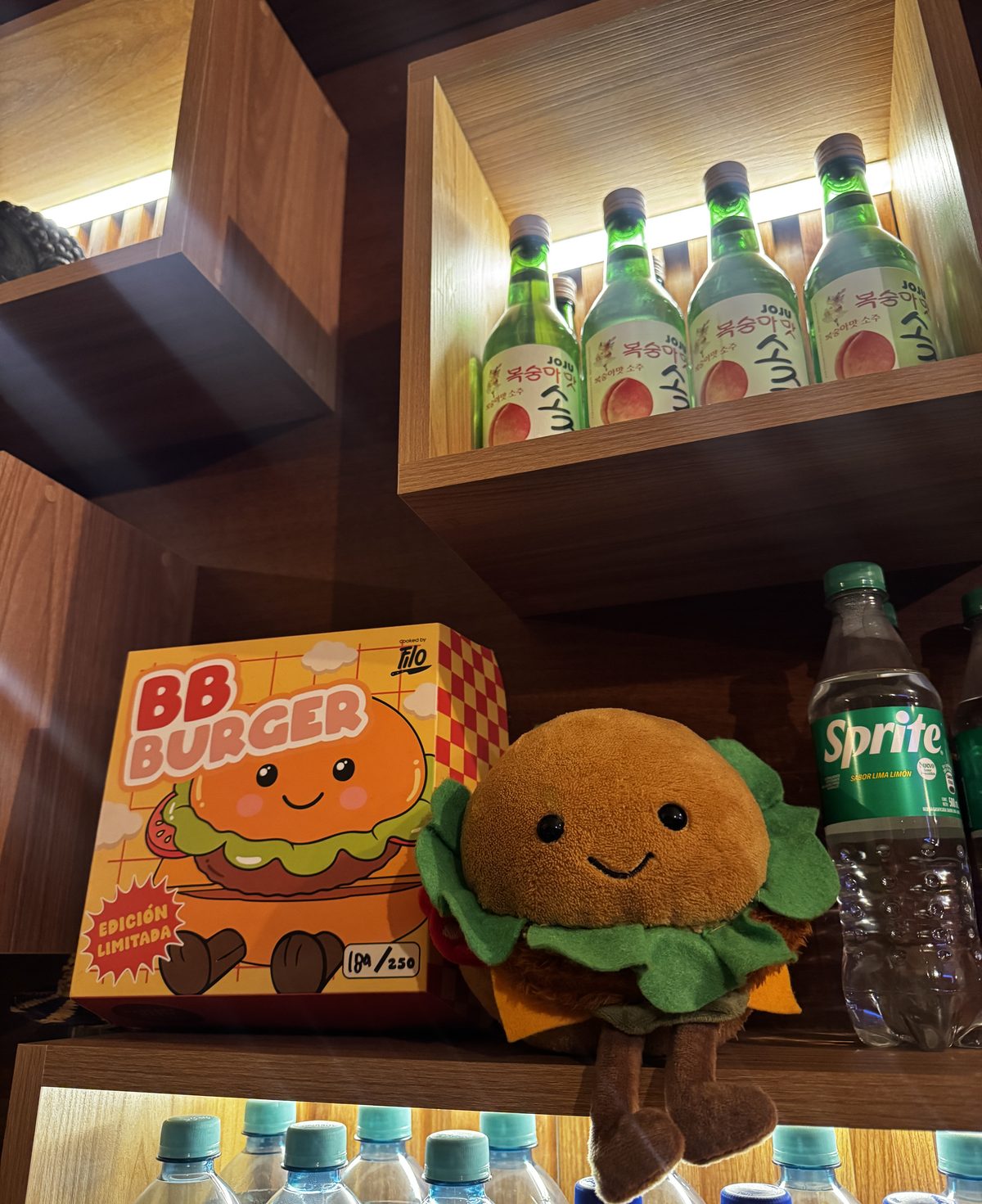 Estantería de Panchita con botellas de soju coreano, gaseosas y el peluche de la casa