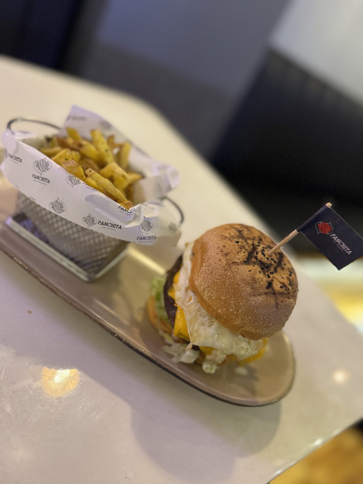 Smash burguer de Panchita con papas y el banderín de la casa